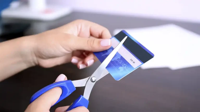 Tesoura cortando um cartão de crédito para simbolizar o fim da dívida no cartão após os gastos de Natal.